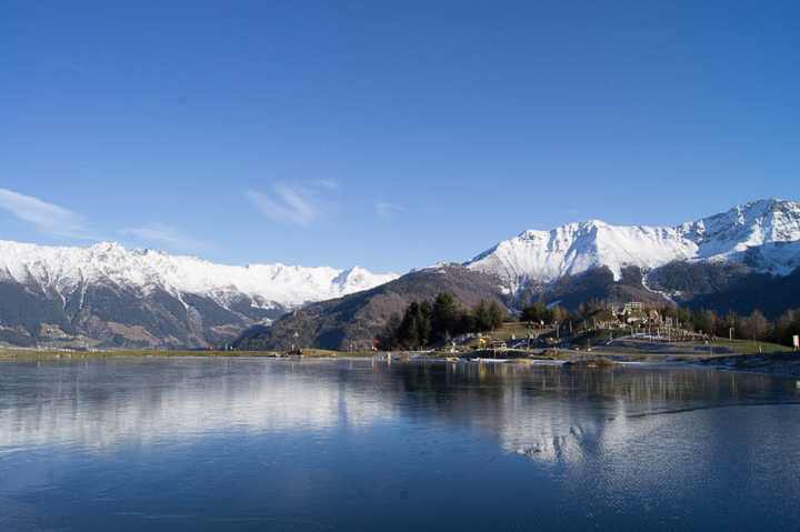 The frozen mountain lake in front of the winter range