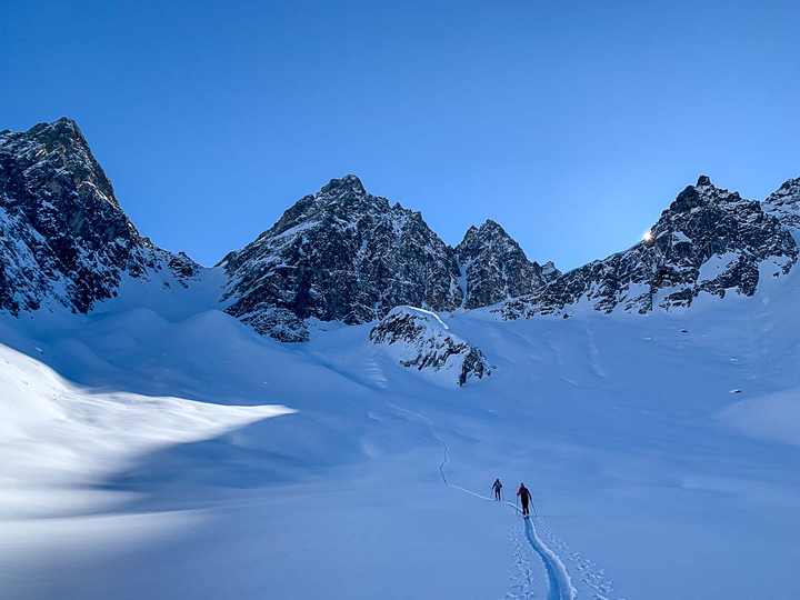 Two ski tourers in a wide snow-filled cirque