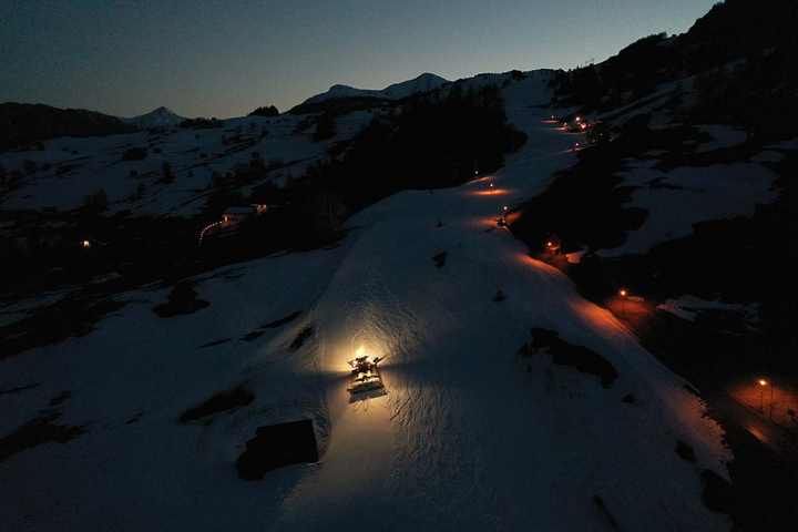 The snow groomer preparing the run for the next day on the slopes